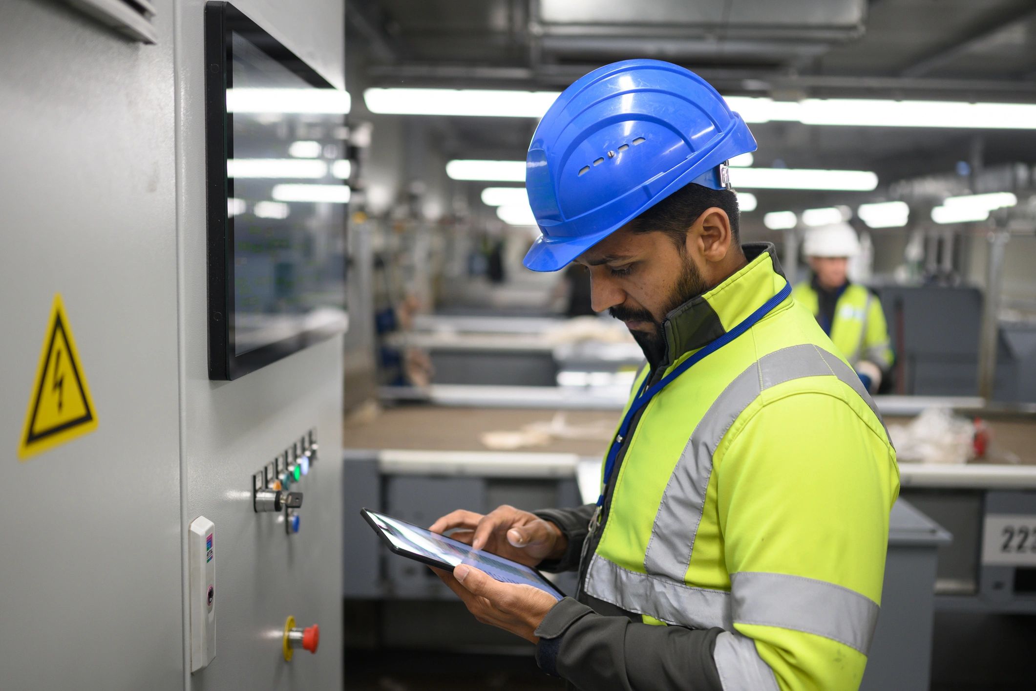 Industrial worker using a tablet near machinery